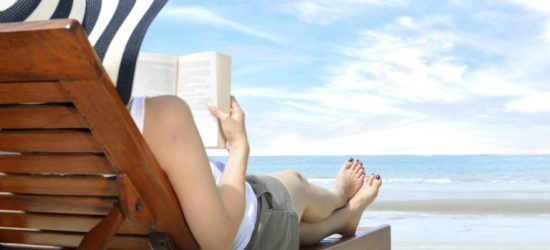 Woman on the beach Young woman reading a book at the beach