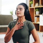 Woman doing breathing exercises while listening to headphones