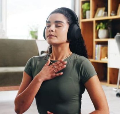 Woman doing breathing exercises while listening to headphones